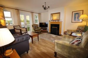 een woonkamer met een bank en een open haard bij Vine Cottage in Charmouth