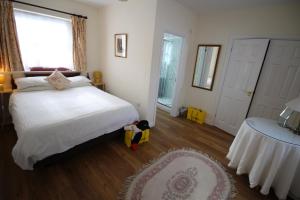 a bedroom with a white bed and a large window at Vine Cottage in Charmouth