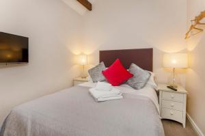 a bedroom with a white bed with red pillows at The Mitchell in York