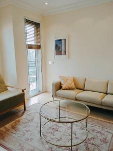 uma sala de estar com um sofá e uma mesa de vidro em Luxury apartment London Kew National Archives em Londres