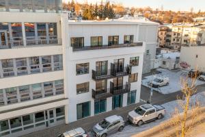 an apartment building with cars parked in a parking lot at LL Properties - Luxury Penthouse in Akureyri