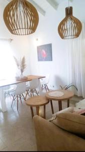 jadalnia z drewnianymi stołami, krzesłami i światłami w obiekcie Casa Deco con Pileta, Asador y Cochera w Córdobie