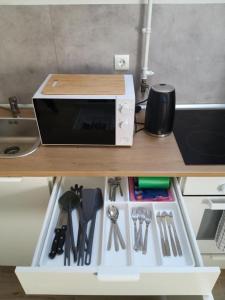 un microondas sobre una mesa con utensilios en Apartment Lenchy en Zagreb