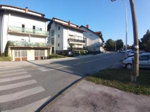 an empty street with cars parked in front of buildings at Apartment Lenchy in Zagreb