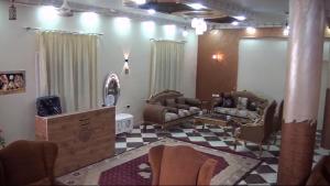 a living room with couches and a checkered floor at فندق لؤلؤة الريف in Kafr ʼakīm