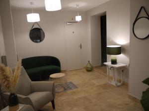 uma sala de estar com um sofá e uma cadeira em Le Trèfle à Quatre Feuilles em Siorac-en-Périgord