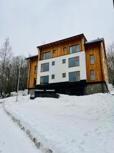 a house in the snow in front at Golden Ridge Apartments in Špindlerův Mlýn
