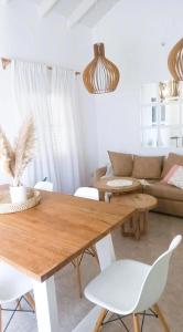 sala de estar con mesa de madera y sillas blancas en Casa Deco con Pileta, Asador y Cochera en Córdoba