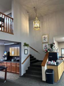 a room with a staircase and a kitchen and a chandelier at De Smet Super Deluxe Inn & suites in De Smet