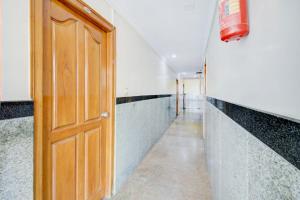 a hallway with a wooden door and a long corridor at OYO Hotel Vijay Residency in Bangalore