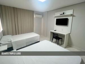 a room with a bed and a desk with a tv at Nox Apart Hotel - Garvey in Brasilia