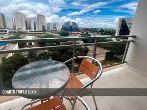a table and chairs on a balcony with a view of a city at Nox Apart Hotel - Garvey in Brasilia
