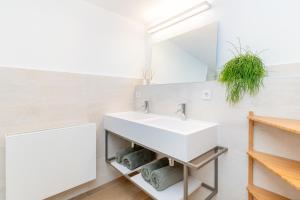 ein Badezimmer mit Waschbecken und Spiegel in der Unterkunft El Huerto - Großzügiges Appartment in Katalanischer Masia in Sant Iscle de Vallalta