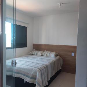 a bedroom with a bed with a glass wall at Apartamento Temporada Salvador Pituba in Salvador