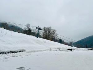 a snow covered slope with a ski lift at Golden Ridge Apartments in Špindlerův Mlýn