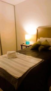 ein Schlafzimmer mit zwei Betten und einem Tisch mit Lampe in der Unterkunft Casa Deco con Pileta, Asador y Cochera in Cordoba