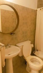 ein Badezimmer mit Toilette, Waschbecken und Spiegel in der Unterkunft Casa Deco con Pileta, Asador y Cochera in Cordoba
