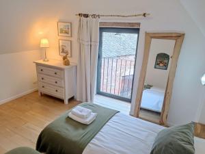 um quarto com uma cama, um espelho e uma janela em ETABLE DE LILOU em Sébrazac