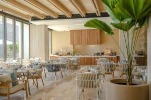 um restaurante com mesas e cadeiras e um vaso de plantas em Grand Velas Boutique Hotel em San José del Cabo