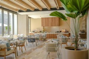 a restaurant with tables and chairs and a potted plant at Grand Velas Boutique Hotel in San José del Cabo