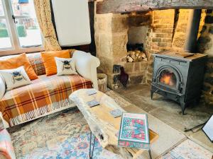 a living room with a couch and a stove at Log Burner and Beamed Ceilings-2 Bed Cottage Crumpelbury and Whitbourne Hall less than a 4 minute drive Dog walking trails and local pub within walking distance and a 30 minute drive to the Malvern Hills in Worcester