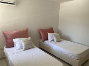 dos camas sentadas una al lado de la otra en una habitación en Nuevo a 10 minutos de Buenavista, en Puerto Colombia