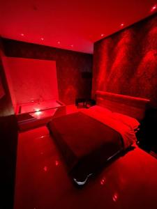 Life Hotel في كازالنووفو دي نابولي: غرفة نوم حمراء مع سرير مع أضواء حمراء