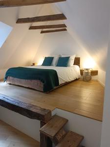um quarto com uma cama e piso em madeira em ETABLE DE LILOU em Sébrazac