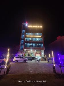 een auto die 's nachts voor een gebouw geparkeerd staat bij Hotel Shivaay Inn in Patna