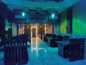 a room with chairs and a stage with green lights at Hotel Shivaay Inn in Patna