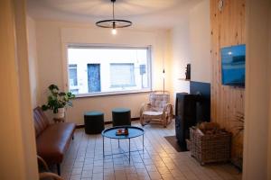 Gaston vakantiehuis في جيرادسبرجن: غرفة معيشة مع أريكة وتلفزيون