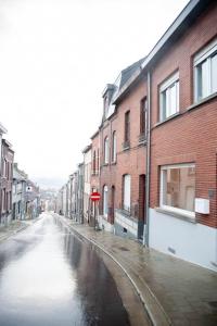 an empty street with buildings on a rainy street at Gaston vakantiehuis in Geraardsbergen