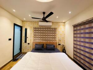 a bedroom with a bed with a ceiling fan at Home Escape Luxe 2BHK Penthouse Near LIG Square in Indore