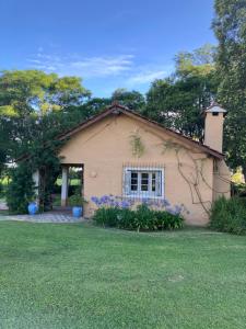 a small house with a window in a yard at La Madreselva in San Antonio de Areco