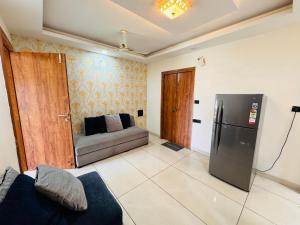 uma sala de estar com um sofá e um frigorífico em Home Escape Luxe 2BHK Penthouse Near LIG Square em Indore