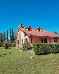 uma casa com um telhado vermelho num jardim verde em Cabaña Lijeron #1 em Samaipata