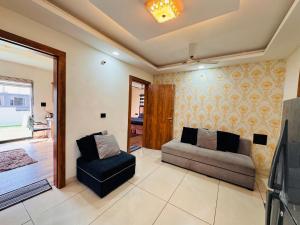 uma sala de estar com um sofá e uma cadeira em Home Escape Luxe 2BHK Penthouse Near LIG Square em Indore