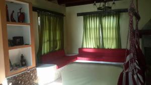 um quarto com duas janelas e um sofá vermelho em Cabaña Lijeron #1 em Samaipata