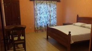 um quarto com uma cama, uma janela e uma cadeira em Cabaña Lijeron #1 em Samaipata