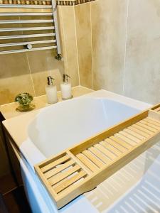 a bath tub with a wooden frame around it at Log Burner and Beamed Ceilings-2 Bed Cottage Crumpelbury and Whitbourne Hall less than a 4 minute drive Dog walking trails and local pub within walking distance and a 30 minute drive to the Malvern Hills in Worcester