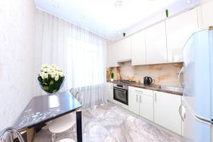 a kitchen with white cabinets and a table with flowers on it at Европейская Пассаж ЦУМ in Dnipro