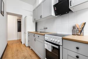 Una cocina con gabinetes blancos y una estufa. en Prime Home CENTRUM 2, en Gdynia 11 fotos más