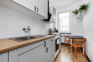 Una cocina blanca con fregadero y encimera. en Prime Home CENTRUM 2, en Gdynia