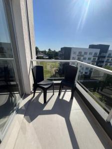two chairs on a balcony with a view of a city at Exclusivo Monoambiente Moderno by G&A Rent (409) in Ezeiza