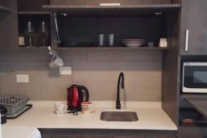 a kitchen counter with a sink and a microwave at Exclusivo Monoambiente Moderno by G&A Rent (409) in Ezeiza