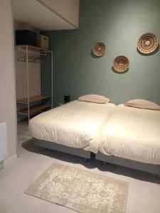 - une chambre avec 2 lits et un mur vert dans l'établissement CozyCocoon Appartement, à Parcey