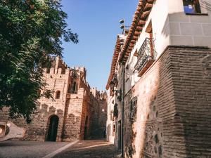 an old stone building with a castle in the background at Casa Airosas in Toledo