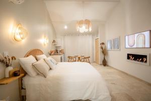 a bedroom with a large white bed and a fireplace at Nuits d'Audace in Alès