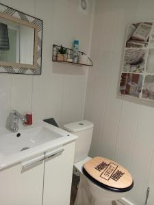 a white bathroom with a toilet and a sink at CozyCocoon Appartement in Parcey