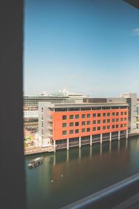 a large orange building next to a body of water at Luxurious 2 Bed - RIVER VIEW in Liverpool